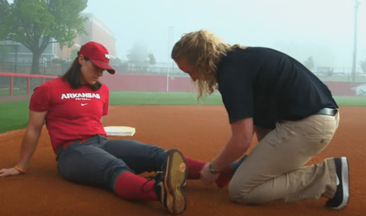 Athletic training student doing clinical work on a softball field